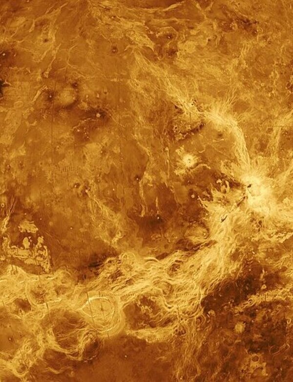 Die Darstellung zeigt den Planeten Venus, der von einer dichten, gelb-orangefarbenen Atmosphäre umgeben ist. Die Oberfläche ist von felsigen und vulkanischen Merkmalen geprägt, die durch Wolken aus Schwefelsäure verborgen sind. Die dunkelsten Stellen deuten auf unterschiedliche geologische Strukturen hin.