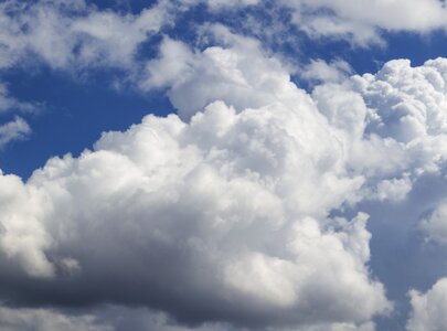 Ein Himmel mit vielen weißen, wolkenartigen Formationen auf einem hellblauen Hintergrund. Die Wolken sind fluffig und variieren in der Dichte, wodurch ein weites und offenes Gefühl entsteht.