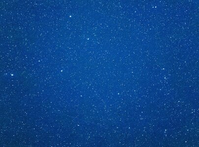 Ein tiefblauer Nachthimmel, durchzogen von vielen kleinen, funkelnenden Sternen. Die Sterne sind gleichmäßig verteilt und variieren in Helligkeit, was dem Bild eine ruhige und majestätische Atmosphäre verleiht.