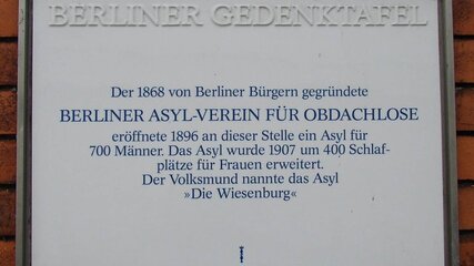 Berliner Gedenktafel, die an den 1868 gegründeten Berliner Asyl-Verein für Obdachlose erinnert. Die Tafel beschreibt die Eröffnung eines Asyls im Jahr 1896 für 700 Männer und die Erweiterung im Jahr 1907 um 400 Schlafplätze für Frauen. Der Name „Die Wiesenburg“ wird erwähnt.